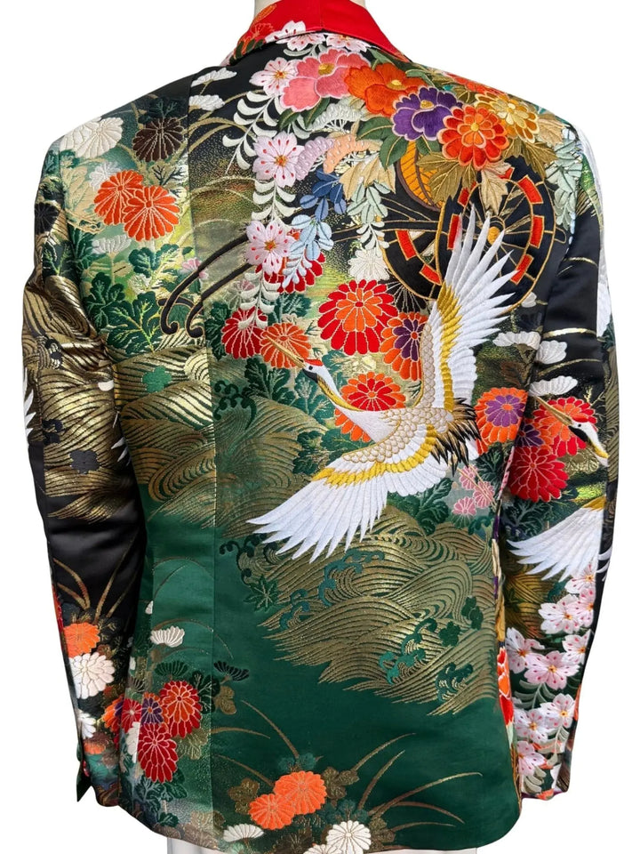 Back view of MIDNIGHT GARDEN KIMONO JACKET with Black satin lapel. Detail of gold embroidered cranes on vintage uchikake silk. Green, pink, orange, red, gold and black colors. Nigel Curtiss.
